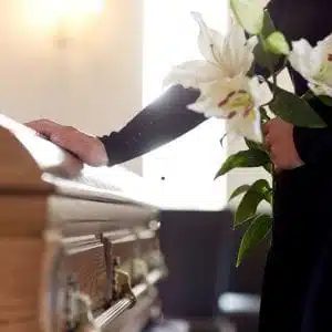 Rito funebre, ultimo saluto con fiori bianchi